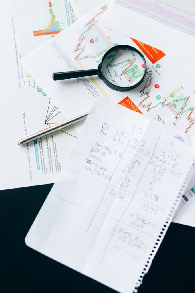 pexels photo 6120168 Financial documents and charts with a magnifying glass, symbolizing analysis and data review.